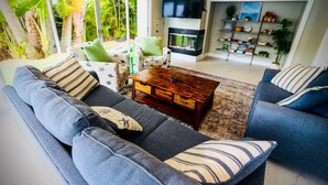 Ein modernes Wohnzimmer mit einer Couch, einem Couchtisch und einem Fernseher.