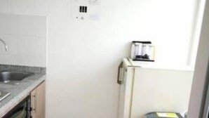 A compact kitchen with a sink, stove, and a small refrigerator. - Studio of a single environment (Armenia)