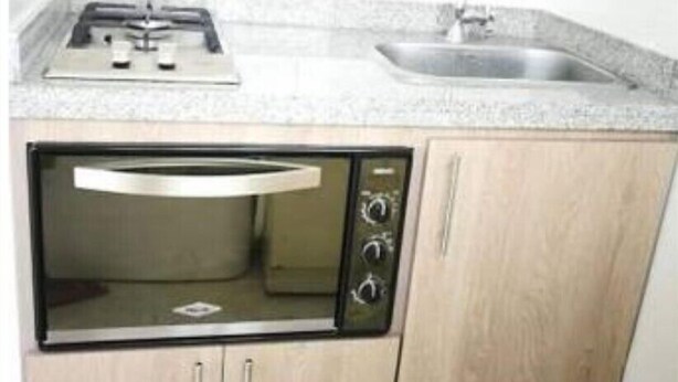 A compact kitchen with a built-in oven, a sink, and a stovetop. - Studio of a single environment (Armenia)