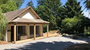 Une petite maison de plain-pied, dotée d’un toit en pente et d’un porche abrité.