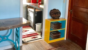 Une cuisine avec une table en bois, un grille-pain rouge et un meuble vert.