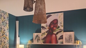 Un dormitorio con cama, dos mesitas de noche, una lámpara de pared, un cuadro y una lámpara colgante.