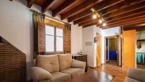 A cozy living room with a sofa, a wooden coffee table, and a staircase.