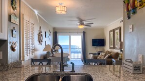 A kitchen with granite countertops, a sink, and a ceiling fan. - Sea Oaks Oceanfront 2-Bed / 2-Bath (Garden City)