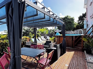 Un espace extérieur aménagé avec une terrasse, une piscine, une plateforme en bois et des sièges.