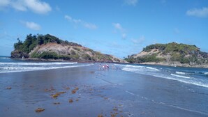 A beach with rocky hills and a cross on one hill. - VILLA C'MARGOT - 110 M2 (MARIGOT)