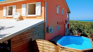 A house with a swimming pool, satellite dish, and a view of the ocean. - VILLA C'MARGOT - 110 M2 (MARIGOT)