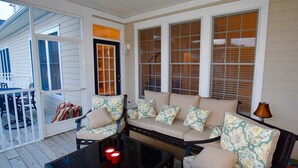 A covered porch with a sofa, chairs, and a table. - Bear Trap Dunes * 3BR Golf Villa (Ocean View)