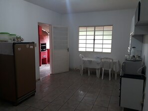 Compact living space with a kitchenette, dining area, and adjacent room with a window.