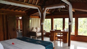 Una habitación amplia con una cama grande, un escritorio de madera y una silla.