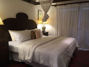A neatly made bed with white linens and multiple pillows, a bedside lamp, and a canopy over the bed. - Cotton Bay Townhouse (Gros Islet)