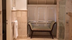 A bathroom with a bench, a glass shower enclosure, and a tiled floor. - Cotton Bay Townhouse (Gros Islet)