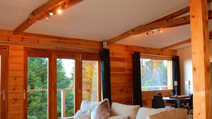 A wooden interior with a sofa, a heart-shaped decoration, and a dining area. - Boutique Alpine Chalet with Panoramic Views next to Ski Lift (Thollon-Les-Mémises)