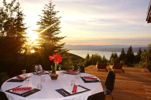 A round dining table set outdoors with a view of the ocean and mountains. - Boutique Alpine Chalet with Panoramic Views next to Ski Lift (Thollon-Les-Mémises)