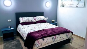 A bedroom with a bed, nightstands, a rug, and a painting on the wall. - Casa del Erizo: Moraira. (Moraira)