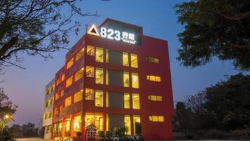 A multi-story hotel building with illuminated windows and a prominent sign at the top.