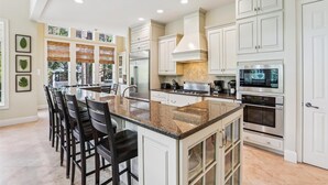 A spacious kitchen with a large island, white cabinetry, and modern appliances. - Beautiful & Spacious 5br Home w/ Private Pool (Hilton Head Island)