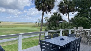 Terraza con mesa y sillas, con vistas a un campo de golf.