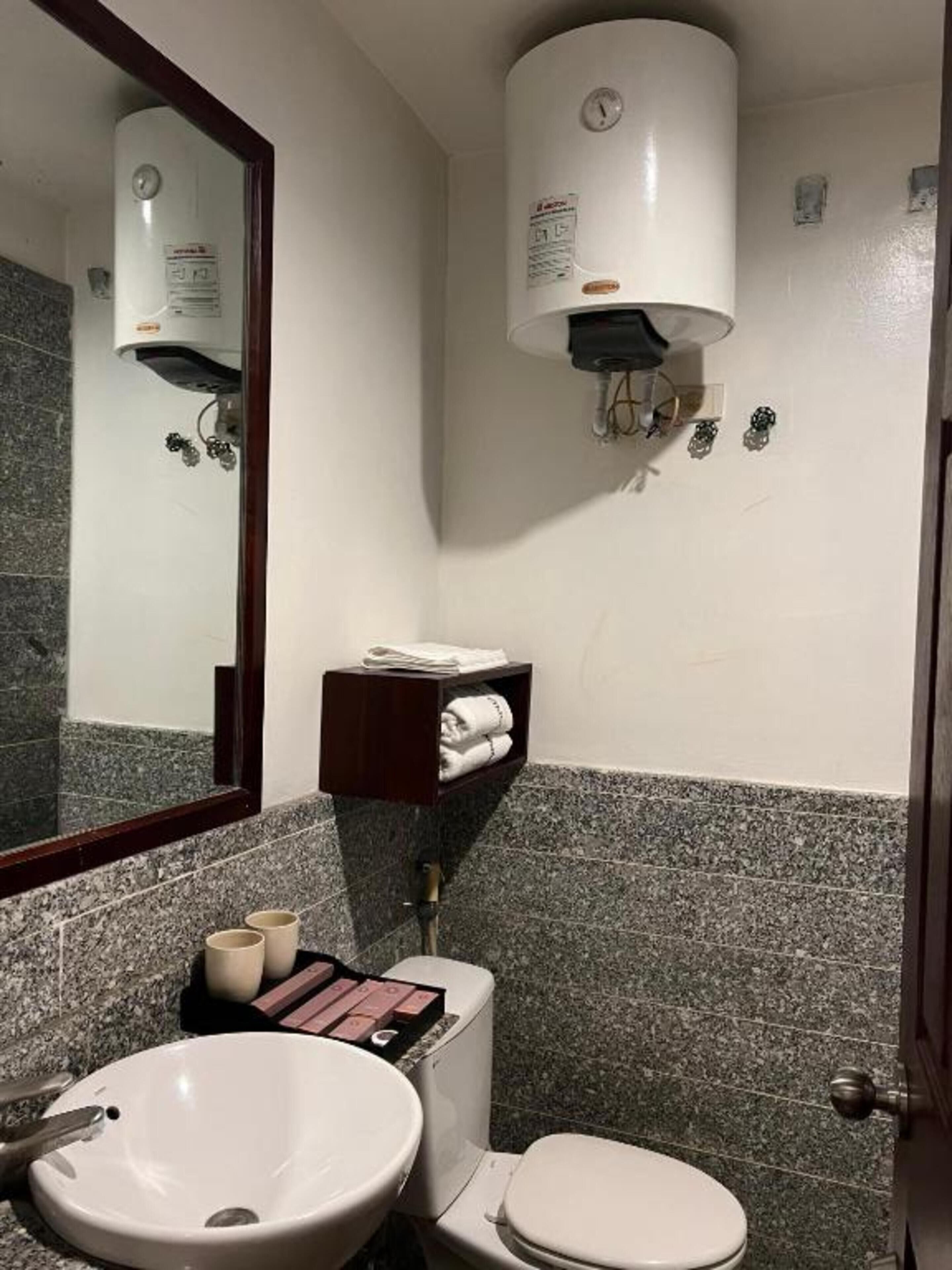 Une salle de bain équipée d’un lavabo, de toilettes et d’un porte-serviettes.