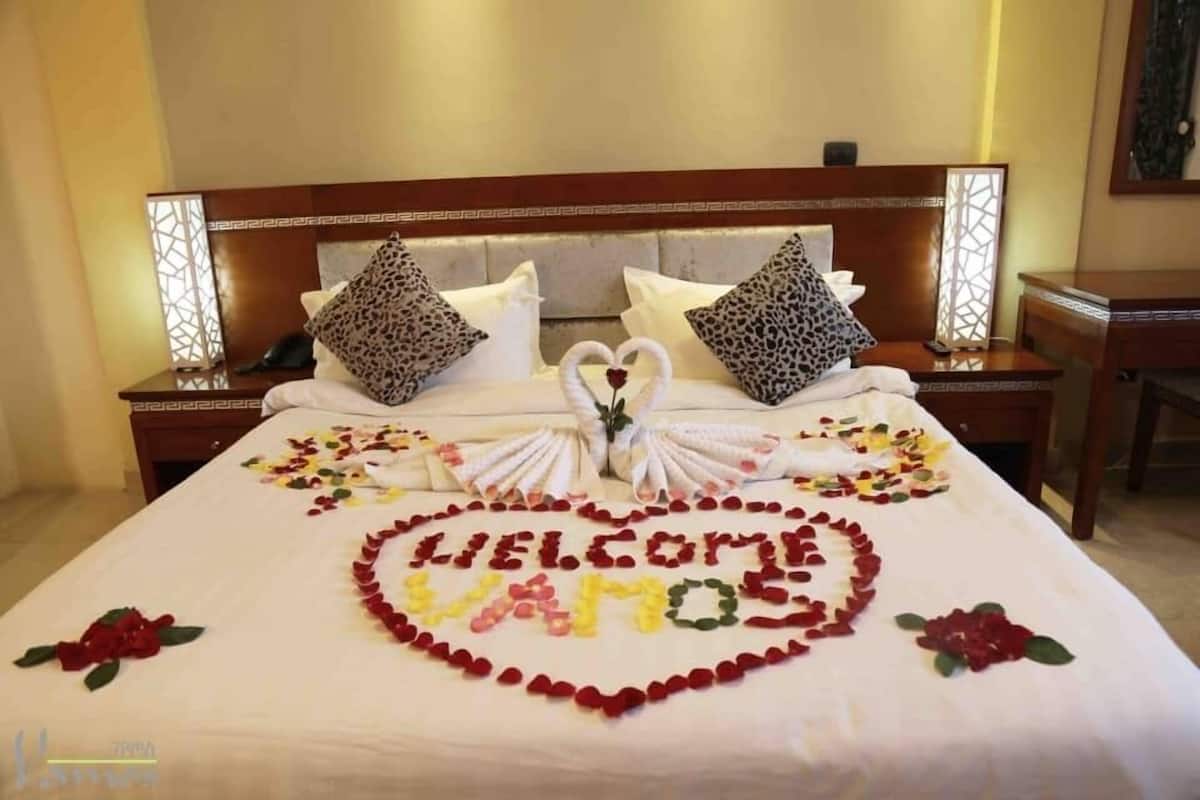 Une chambre d’hôtel avec un lit décoré d’un message de bienvenue en forme de cœur et des serviettes en forme de cygne.