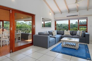 A spacious living area with a sofa set, a dining table, and a view of the outdoors. - San Lameer Villa Rentals 10427 (Southbroom)