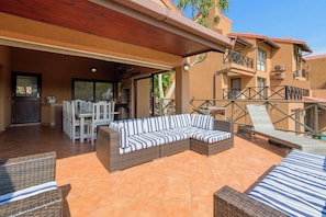 An outdoor patio area with a wicker sofa, dining table, chairs, and a grill. - San Lameer Villa Rentals 10427 (Southbroom)