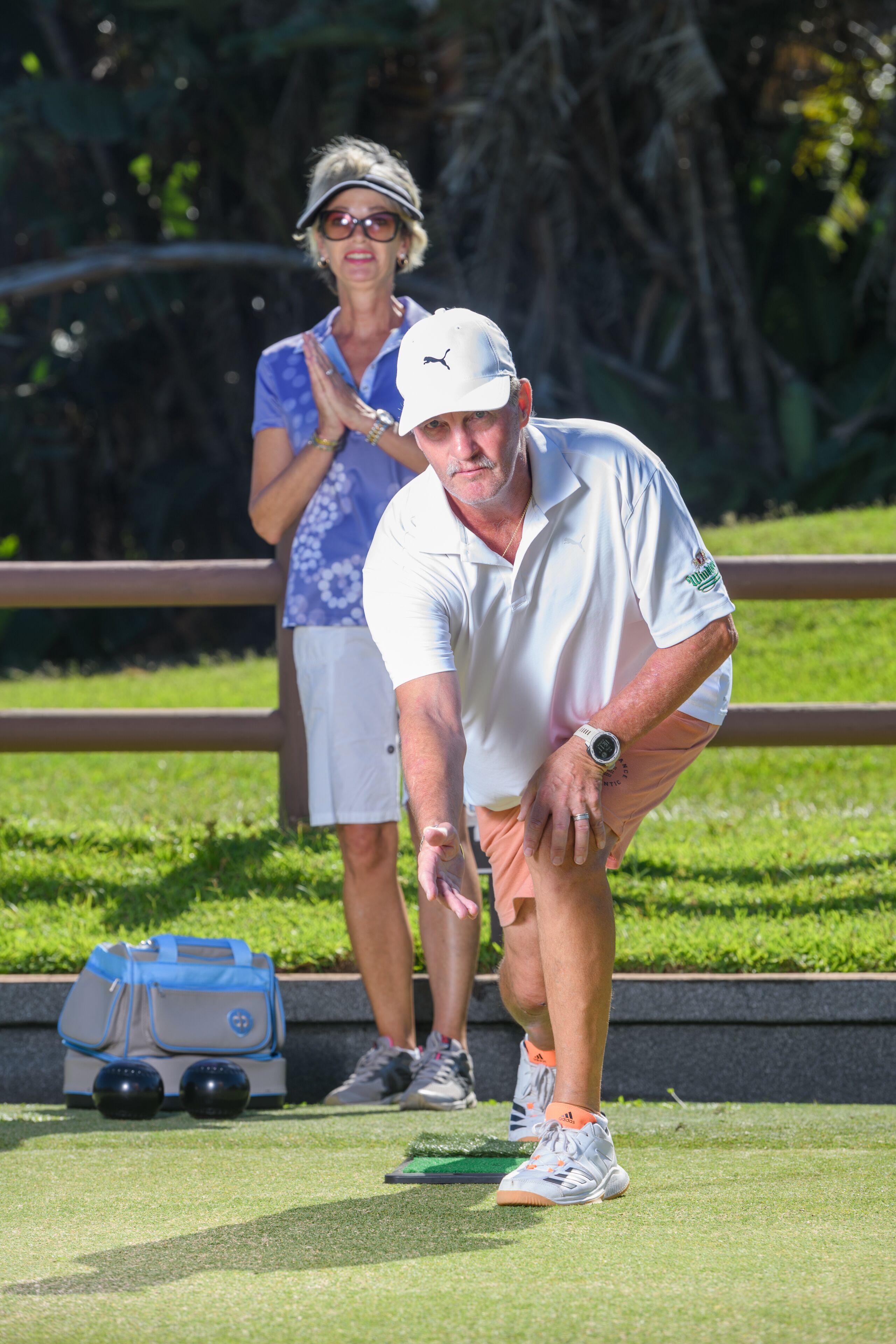 Un parcours de golf avec un green d’entraînement, une boîte de balles de golf et un sac de golf.