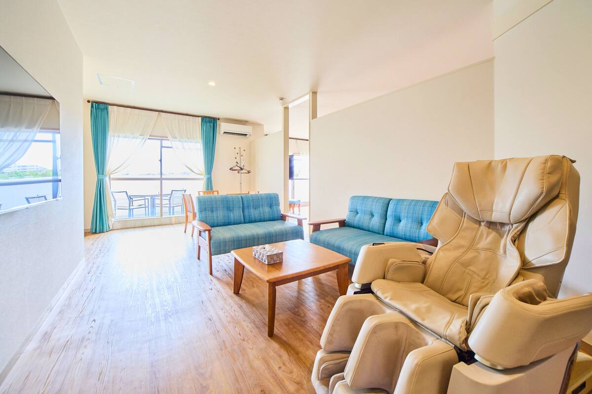 A spacious living area with a sofa, a recliner, and a wooden coffee table.