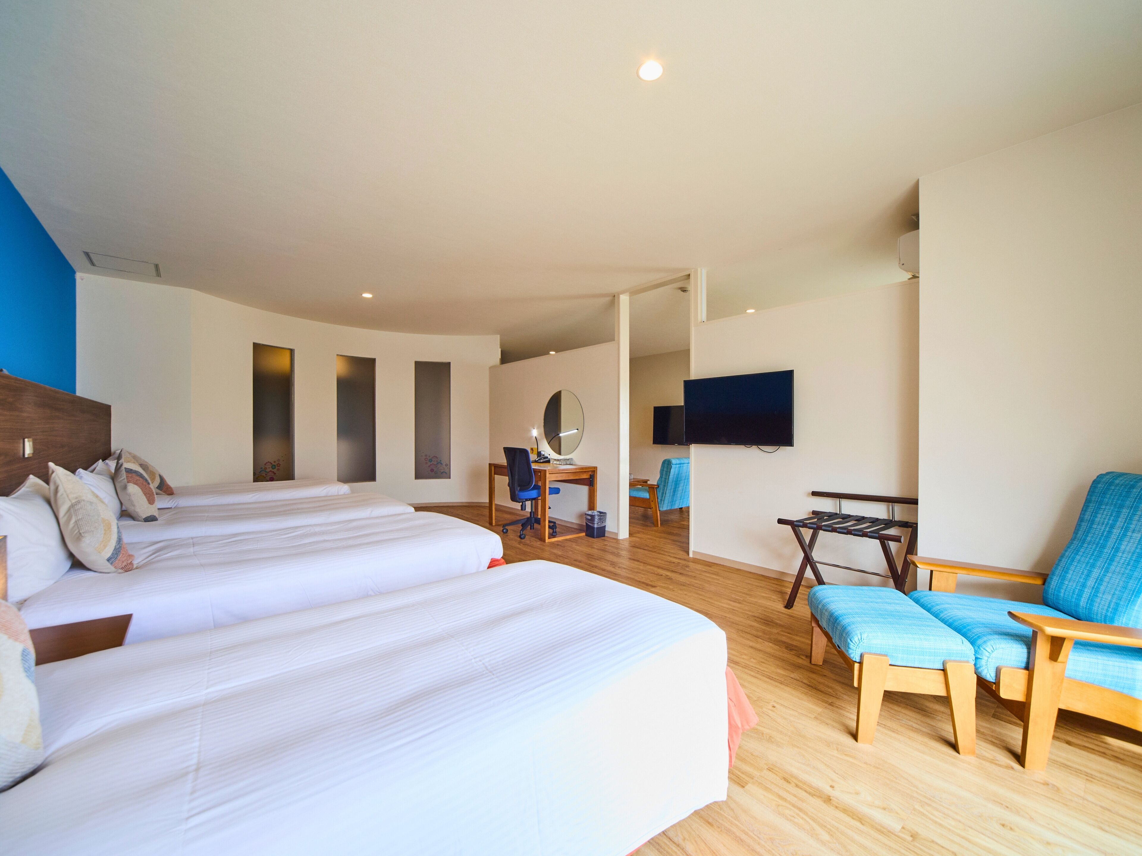 Een hotelkamer met twee bedden, een bureau, een stoel, een televisie en een klein tafeltje.