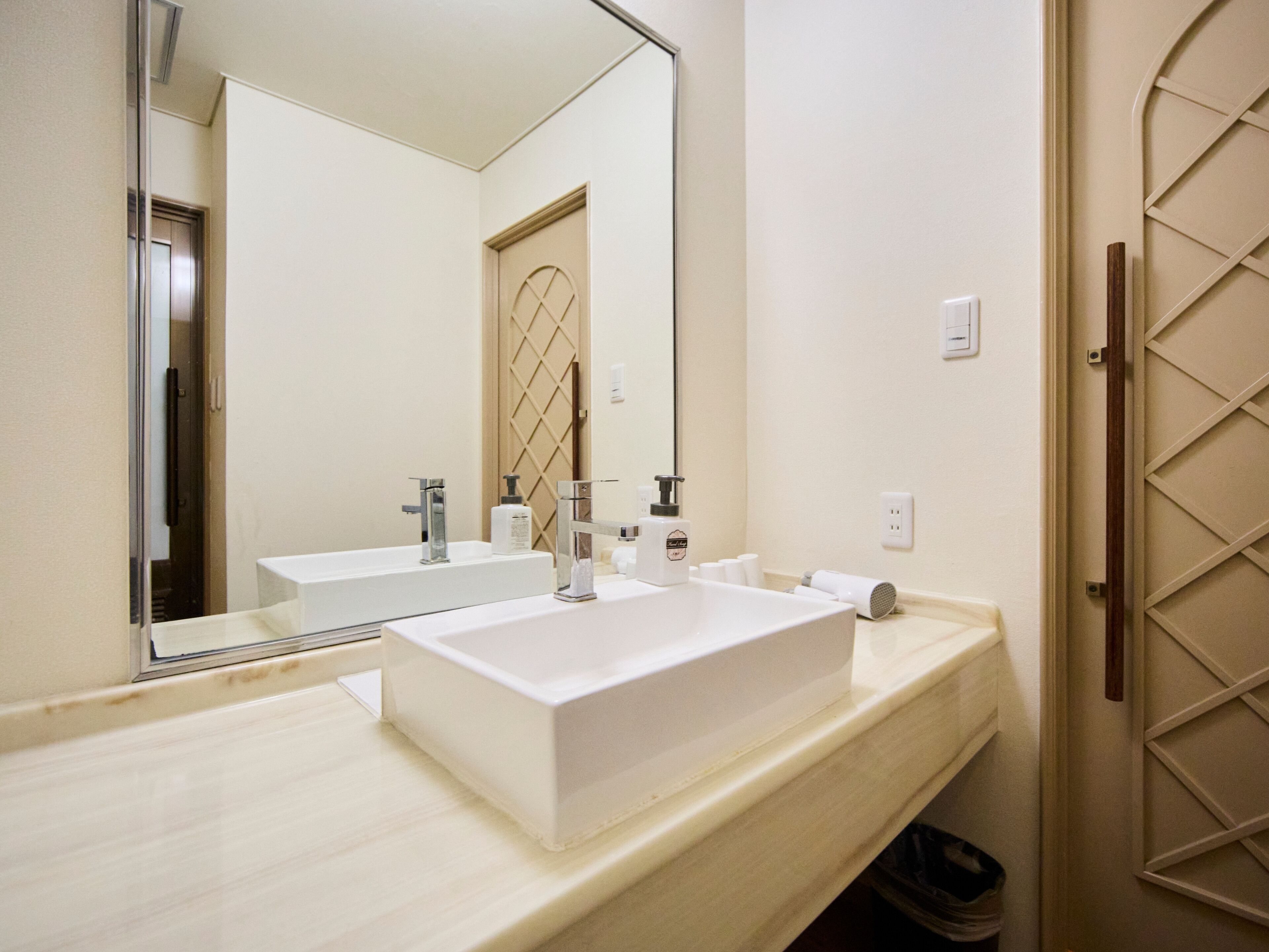 A bathroom with a large mirror, two sinks, and a towel rack.