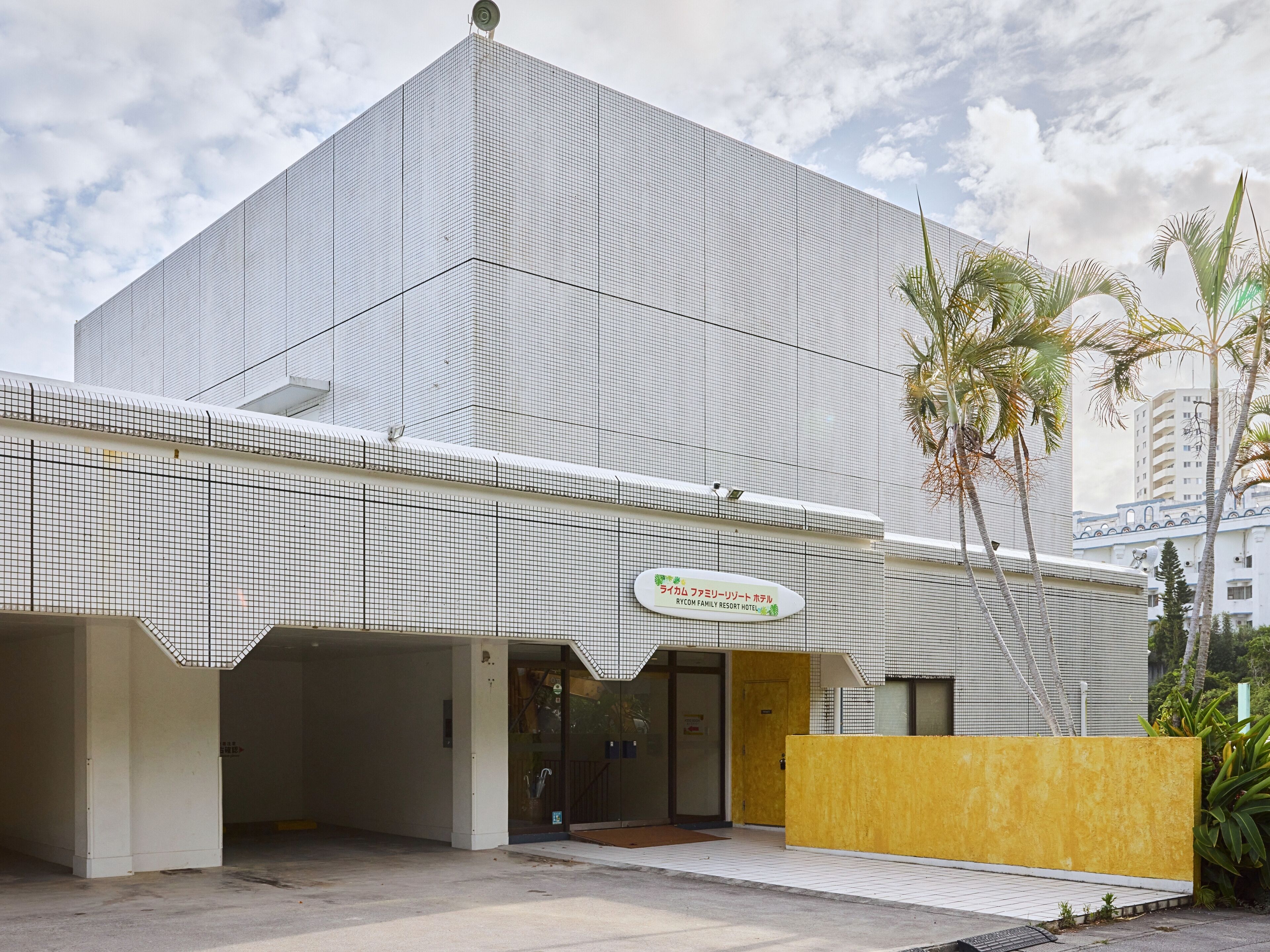 Un edificio moderno con un letrero para el hotel Rycom Family Resort.
