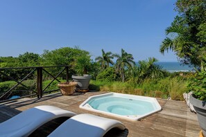 A wooden deck with a hot tub, lounge chairs, and a view of the ocean. - San Lameer Villa Rentals 13917 (Southbroom)