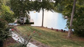 Une propriété située au bord d’un lac, dotée d’une pelouse verdoyante, d’un chemin pavé et d’un petit quai.