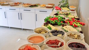 A buffet table with various food items and a plant in the background. - Kas Otel (Kas)