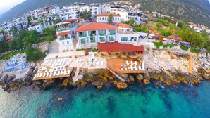 A coastal hotel with a terrace overlooking the sea, featuring multiple lounge areas and a restaurant. - Kas Otel (Kas)
