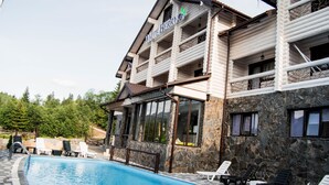 Ein Poolbereich mit Liegestühlen und einem Gebäude mit der Aufschrift "White Berry".