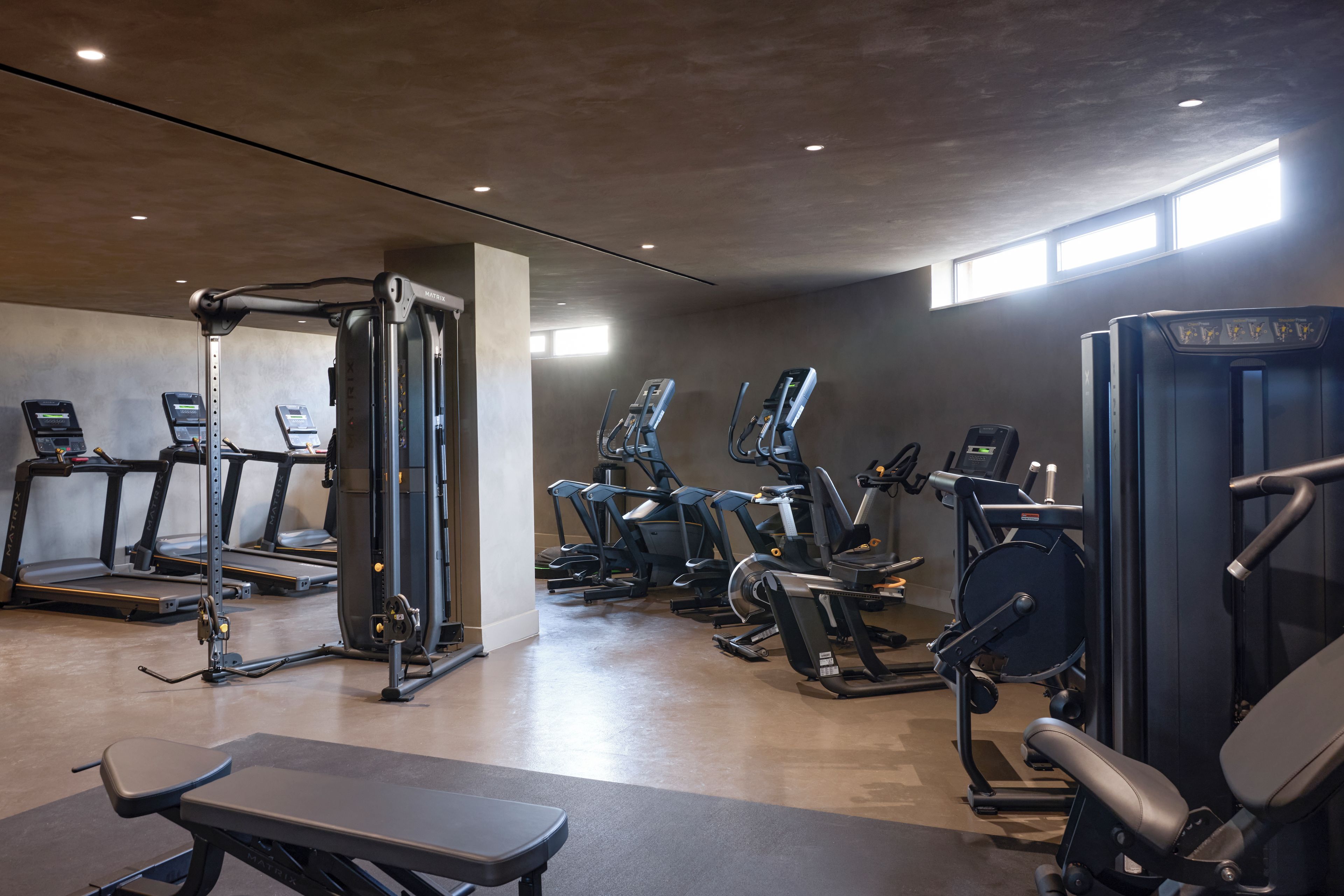 Ett gym med löpband, crosstrainers och styrketräningsutrustning.