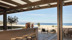 An outdoor seating area with a view of the beach and ocean.