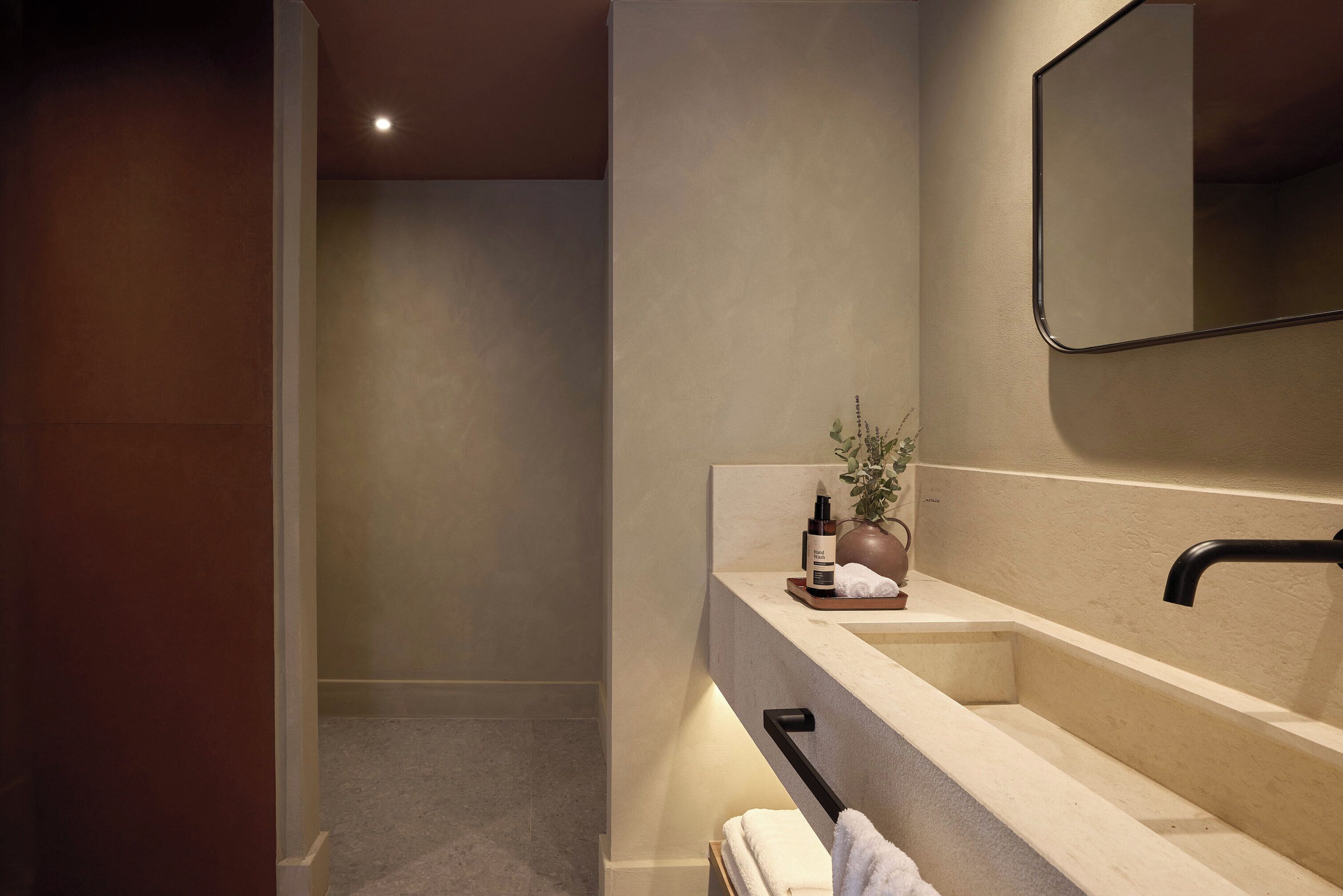 Une salle de bain moderne avec un grand miroir, un lavabo et un porte-serviettes.