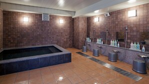 Une salle de bain moderne avec une grande baignoire, plusieurs lavabos et un miroir.