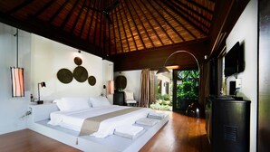 A spacious bedroom with a large bed, wooden flooring, a ceiling fan, and a television on a cabinet. - Tamarind Exclusive Villa (Sattahip)