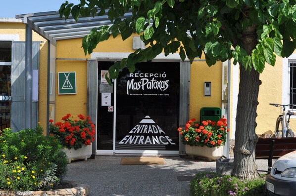 A building entrance with a sign reading "RECEPCIÓ Mas Patoxas" and "ENTRADA ENTRADA".