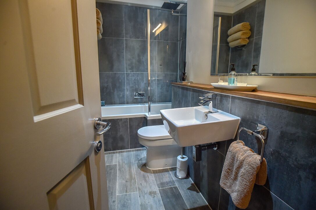 A modern bathroom with a bathtub, toilet, and sink.