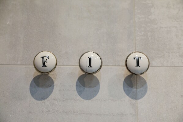 Three round, white buttons with the letters "F", "I", and "T" on a tiled wall. - The Kingsbury at No7 & No8 (Marlborough)