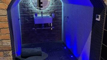 A brick archway leading to a bathroom with a sink and a chair.