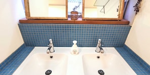 A bathroom with two sinks, blue tiled backsplash, and a mirror above. - Guest House Komatsuya - Hostel (Tokyo)