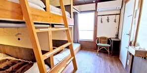 A bunk bed room with a ladder, a desk, and a chair. - Guest House Komatsuya - Hostel (Tokyo)