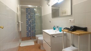 A bathroom with a shower, toilet, sink, and a mirror. - Arbiter Apartments - L'amphora (Napoli)