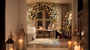 A hallway with a floral archway, a sofa, a table with candles, and lanterns. - Nam Cuong Nam Dinh Hotel (Nam Dinh)