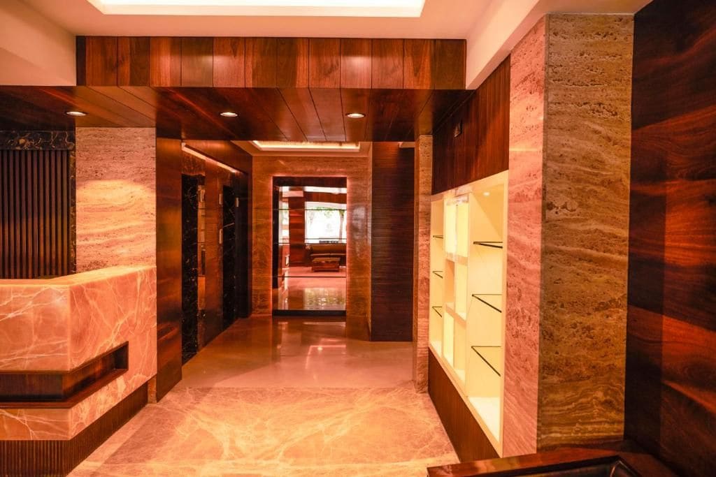 A hallway with a marble floor, wooden paneling, and a glass display case.